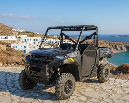 Three-seater buggy rental in Milos with sea views and traditional village surroundings