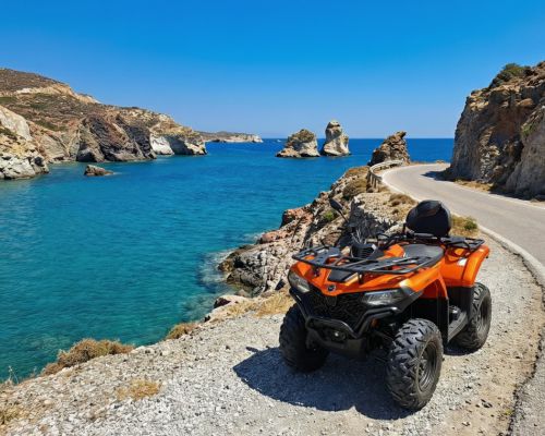 A 450cc ATV rental on a coastal road in Milos with a sea view